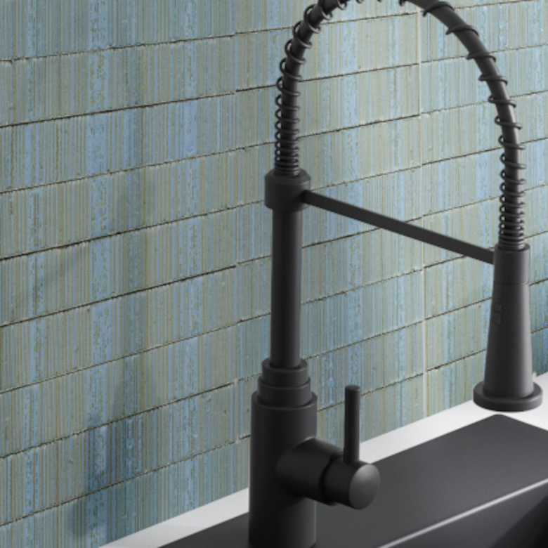Close up of gray kitchen sink standing on white countertops.